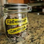 retirement_savings_money_jar-_a_clear_glass_jar_filed_with_coin